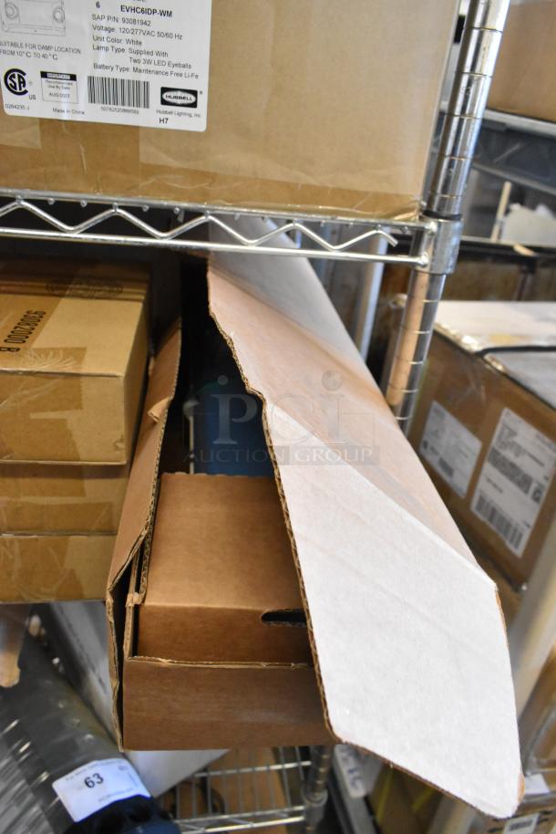 16 brand new scratch and dent boxes containing exit signs, Dual Lite LED emergency light back box, and Dual Lite double remote head. Packaging shows minor wear.