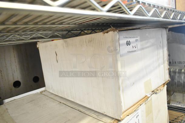 Box of 6 brand new exit signs with scratch and dent, visible label "60 QTY," on a metal shelf.