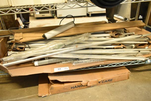 Two boxes of various new fluorescent lights, including Banner WBL32C285PB, shown in packaging. Scratch and dent condition.