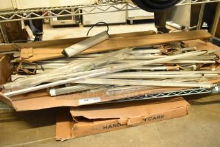 Two boxes of various new fluorescent lights, including Banner WBL32C285PB, shown in packaging. Scratch and dent condition.