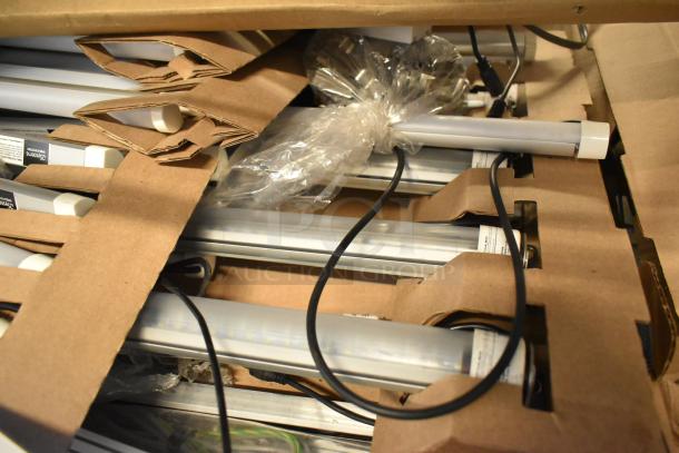 Two boxes of brand new, scratch and dent fluorescent lights, including Banner WBL32C285PB, packaged in cardboard and plastic.