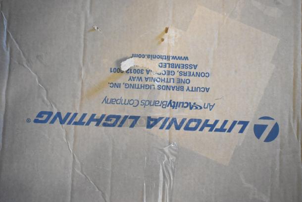 Two boxes of various fluorescent lights, including Banner WBL32C285PB, brand new with some box wear. Lithonia Lighting label visible.