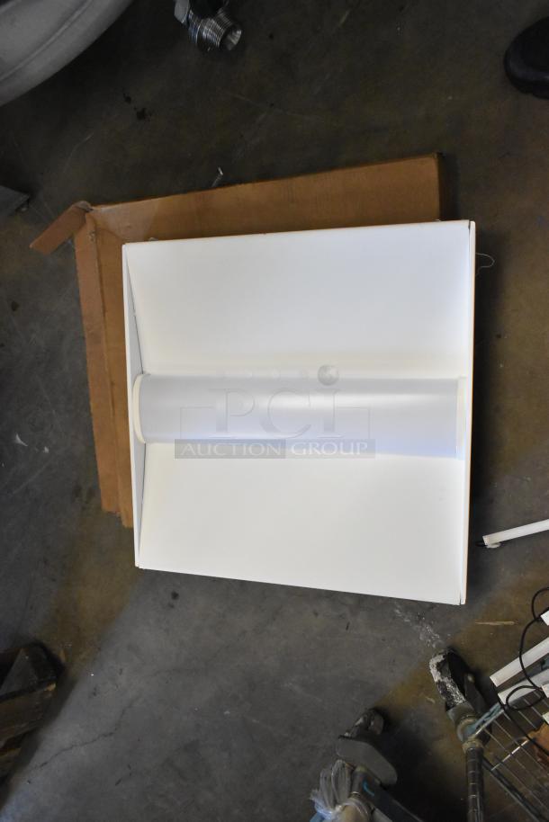 Boxes of various fluorescent lights, including Banner WBL32C285PB, brand new with scratches and dents, laid flat on cardboard.