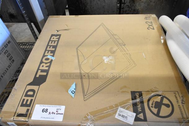 Cardboard box for LED Troffer, labeled "2x2 ft" with visible warning signs. Box shows slight wear. Part of an 8-item auction lot.