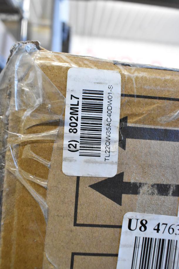 Cardboard box with barcode labels containing auction items like LED troffer and filter pumps. Marked "802ML7".