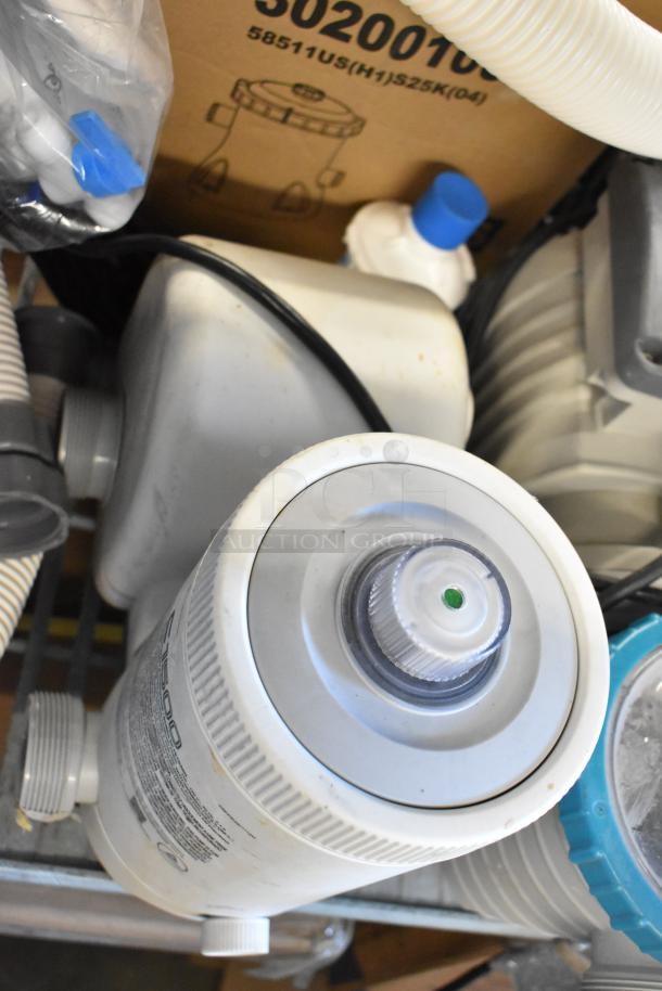 Assorted items including LED troffer, filter pumps, and hoses. Visible markings with product details and conditions.