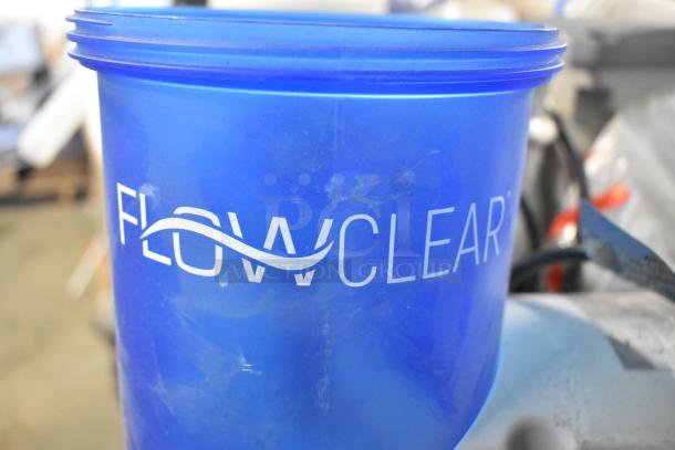 Blue FLOWCLEAR container from auction lot, possibly part of various items including LED Troffer, filter pumps.