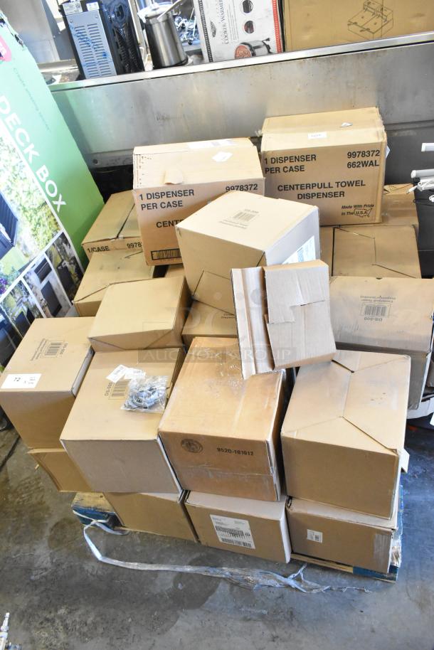 23 boxes of brand new scratch and dent center pull towel dispensers stacked on a pallet, various visible box labels.