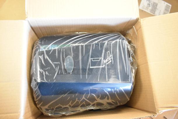 23 new scratch and dent center pull towel dispensers, packaged in a cardboard box. Sealed in plastic wrap, includes user icons.