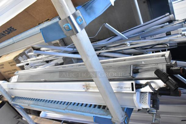 Assorted fluorescent tube lights, various conditions, stacked on metal shelves. Some visible wiring and connectors.