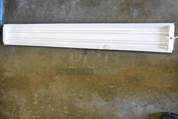 Set of 7 white linear light fixtures, in good condition, featuring LED bulbs. Ideal for commercial or industrial use.
