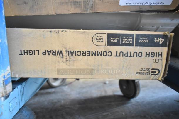 Cardboard box labeled "High Output Commercial Wrap Light, LED, 8000 Lumens," on a blue cart. Contains 7 light fixtures.
