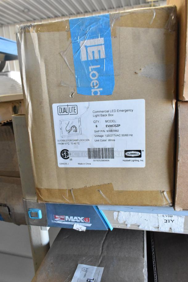 Box containing Dual Lite EVHCEZP LED Emergency Lights, model for damp locations, 120/277VAC, white, 12 items total.