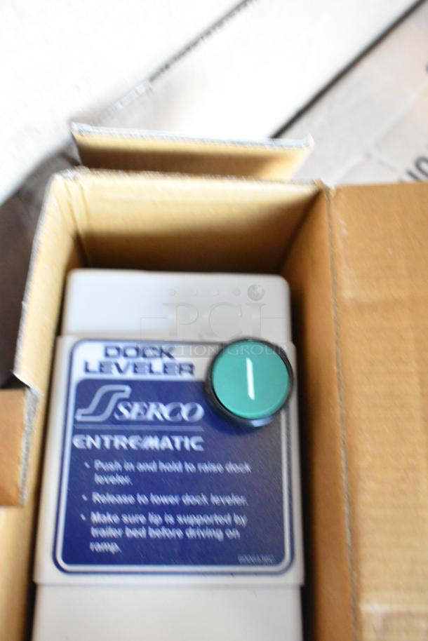 Serco Enteematic dock leveler control panel in box with push button, labeled instructions for raising and lowering.