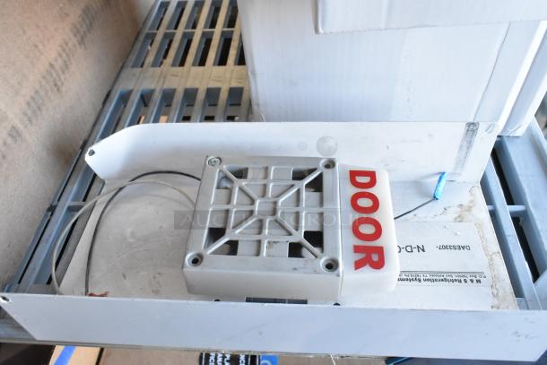 6 items including an emergency light, visible signage labeled "DOOR," placed on a metal shelf, used condition.
