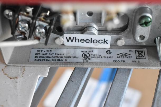 Wheelock emergency light device with labels indicating model 31T-115, UL and FM approved, for audible appliance use.