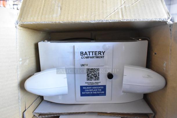 Emergency light in cardboard box, featuring "BATTERY COMPARTMENT" label with QR code and instructions for replacement.