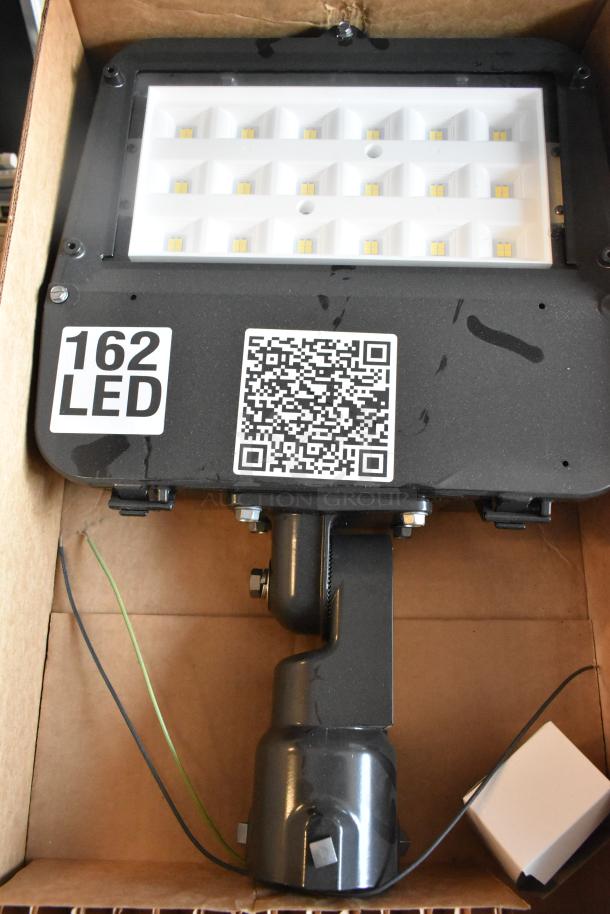 LED flood light, labeled "162 LED," with QR code, boxed. Appears in new condition. Auction includes two additional items.