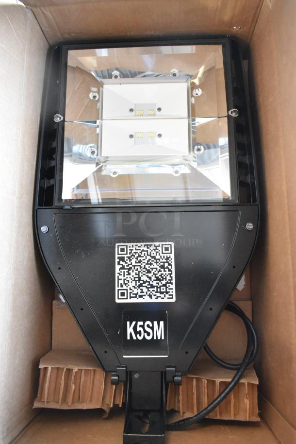 LED flood light in box, black casing, K5SM label, QR code visible, new condition, part of a 3-item auction lot.