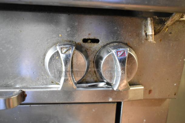 Close-up view of Southbend gas range control knobs, slightly worn, indicating commercial use. Stainless steel finish.