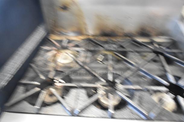 Southbend stainless steel commercial gas range with 6 burners, oven, and backsplash. Visible wear on burners.