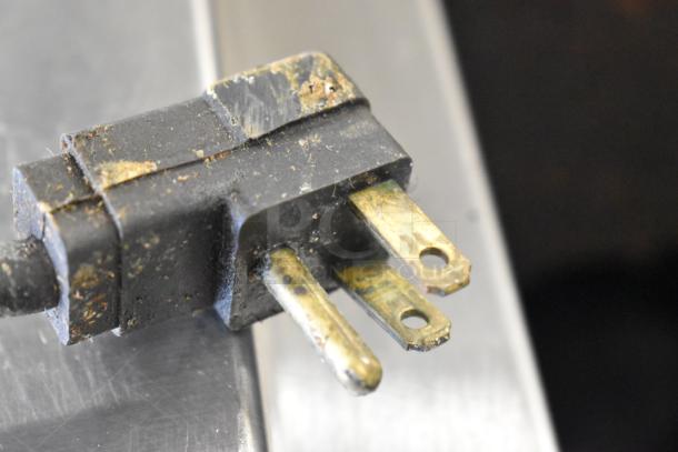 Close-up of a worn plug on the Delfield Stainless Steel Commercial Pizza Prep Table, 115 volts, 1 phase.