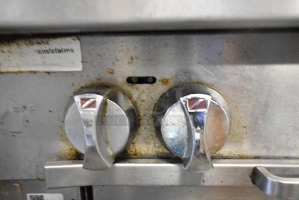 Southbend P36G-BBB range control knobs with visible wear, stainless steel, gas-powered. Label shows model information.