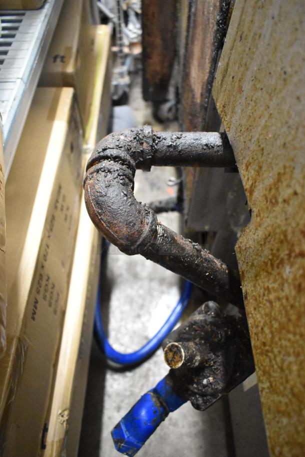 Close-up of Southbend P36G-BBB range gas connection, showing rust and grime. Condition suggests need for maintenance.