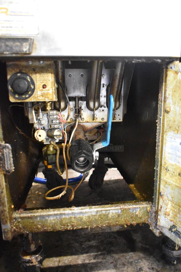Pitco Frialator stainless steel commercial deep fat fryer interior with control knobs and wiring, showing signs of use.