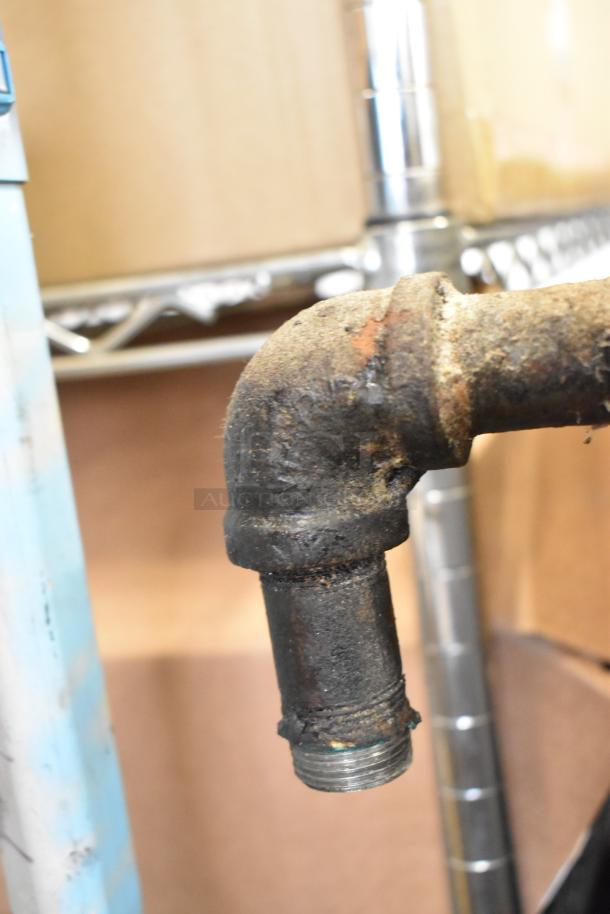 Close-up of a pipe elbow, showing rust and wear, part of the Bakers Pride 4151 pizza oven assembly.