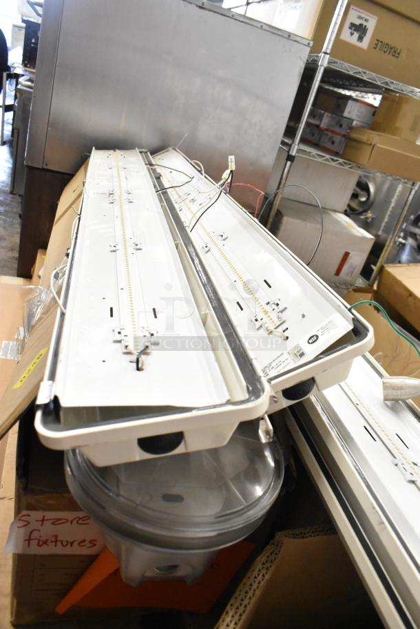 24 lighting fixtures and components, assorted designs, in storage. Some wiring visible. "Store fixtures" label on box.