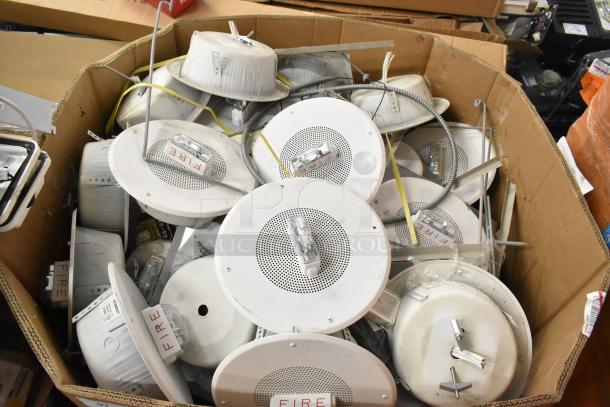 36 Wheelock CBB-8 speaker enclosures with fire alarm lights, boxed, showing "FIRE" labels, suitable for safety systems.