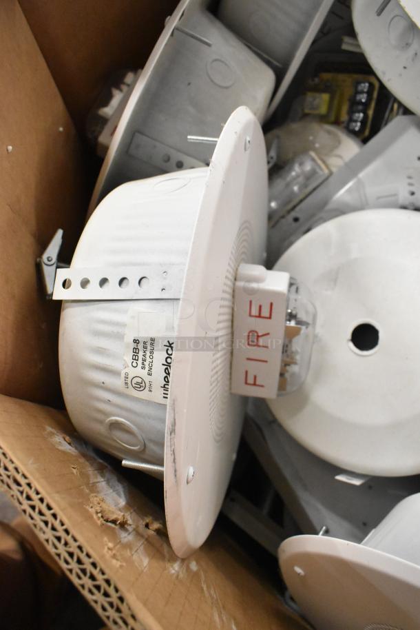 36 Wheelock CBB-8 speaker enclosures with fire alarm lights; features labels and mounting hardware; appears in good condition.