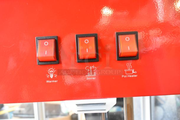 Red control panel of a Carnival King 382PM1360 popcorn machine showing three switches labeled warmer, stirrer, and pot heater.