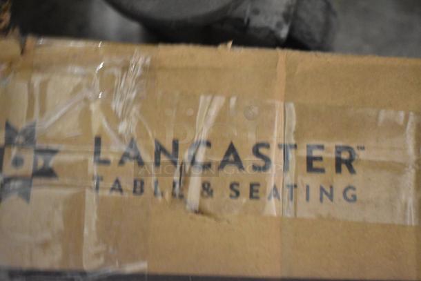 Lancaster Table & Seating table base packaging with visible logo. Describes a bar height, rustic walnut finish, scratch and dent item.