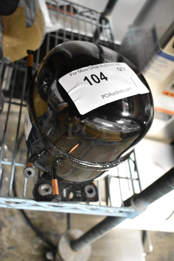 Brand new Cubigel NUT90LR compressor, 115-127 volts, 1 phase. Notable for scratch and dent condition, visible auction label.