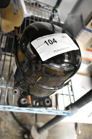 Brand new Cubigel NUT90LR compressor, 115-127 volts, 1 phase. Notable for scratch and dent condition, visible auction label.