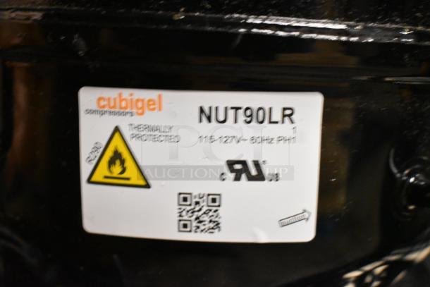 Cubigel NUT90LR compressor, 115-127 volts, 1 phase, thermally protected, with safety label and QR code, scratch and dent condition.