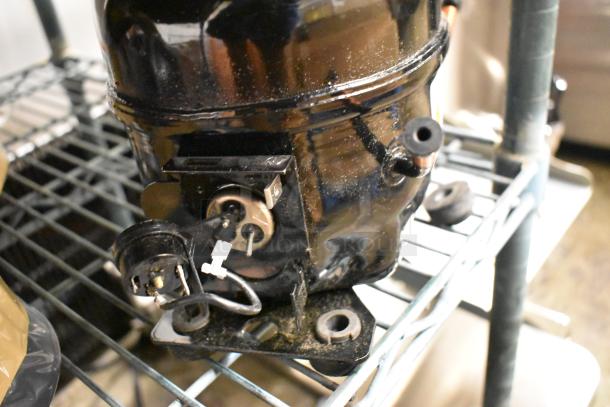 Cubigel NUT90LR compressor, brand new, scratch and dent condition, 115-127 volts, 1 phase, visible wiring.