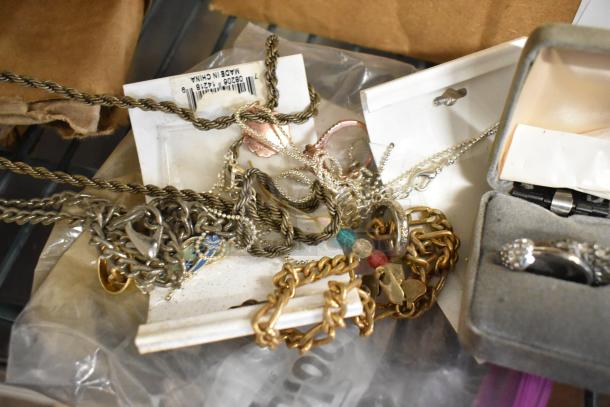 Lot of various jewelry including chains, rings, and bracelets in mixed metals; condition varies. Visible label reads "Made in China."