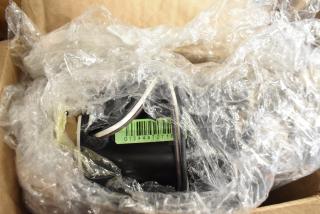 Brand new scratch and dent remote fan motor in protective plastic wrap, barcode G1244470716 visible.
