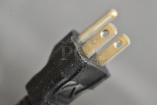 Close-up of a black electrical plug for the Bunn ITCB-DV coffee and tea brewer, 120 volts, shown with prongs.