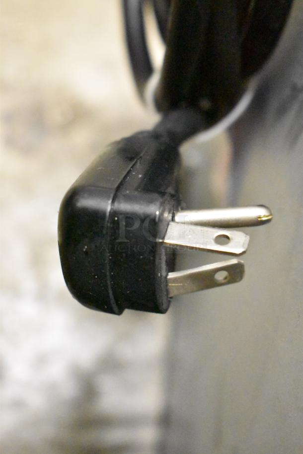 Close-up view of the plug of a 2025 Amana RC22S2 commercial microwave, showing 208/240V compatibility.