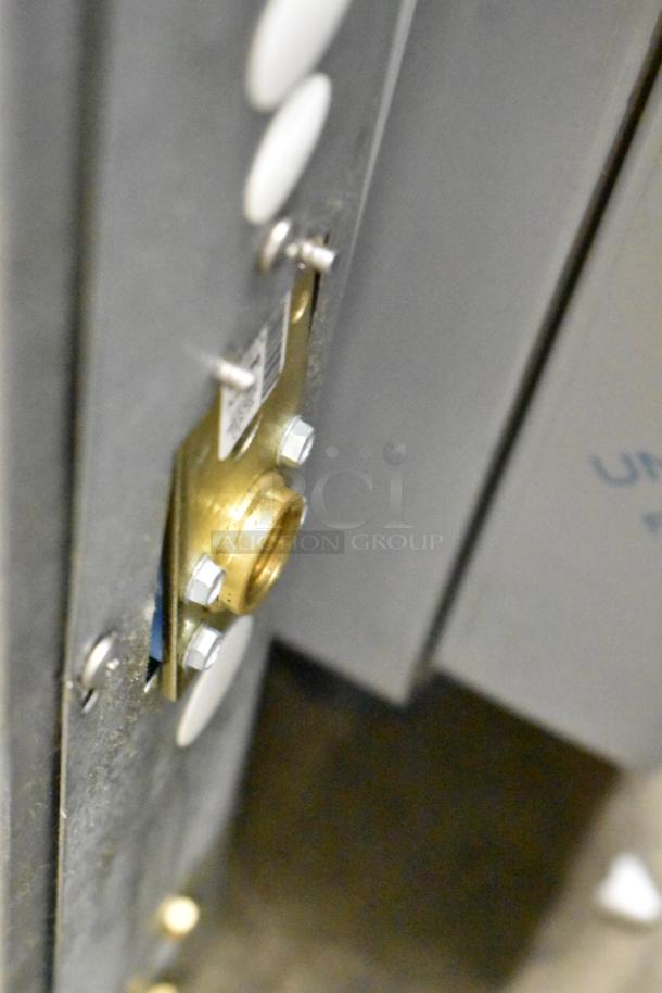 Close-up of Scotsman MC0530MAX-1A ice machine connector. Brass fitting on stainless steel surface; brand new, minor scratches.