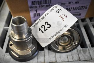 Brand new metal units with slight scratches and dents, auction tag reads '123, Qty 2', bid multiplier noted.