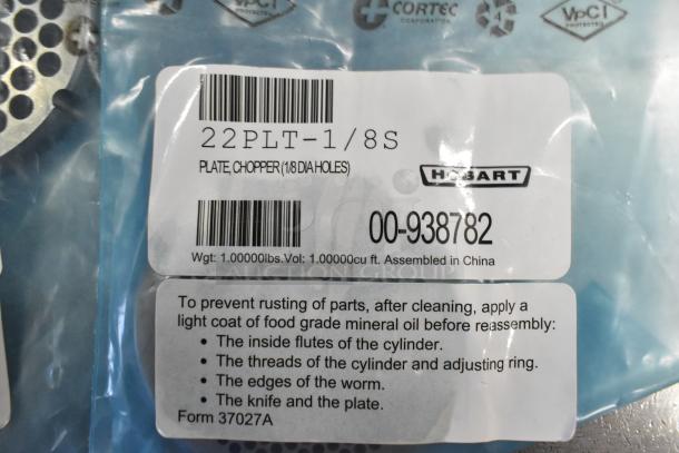 Seven brand new Hobart grinder plates, model 22PLT-1/8S, for meat choppers. Scratch and dent condition.