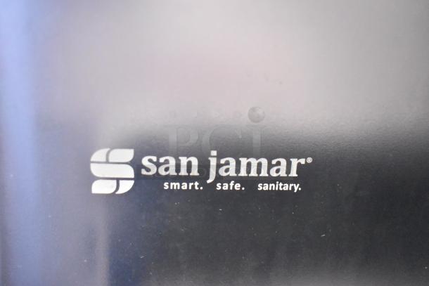 San Jamar wall mount paper towel dispenser, black, brand new with minor scratches, logo and "smart. safe. sanitary." text.