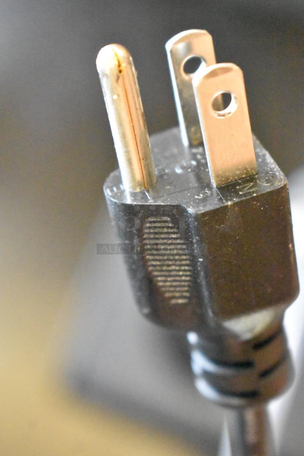 Close-up of a 3-prong plug from a Fetco DRNX SLM DUO Nitro Cold Brew Dispenser, 120V, 1 Phase, minor scratches visible.