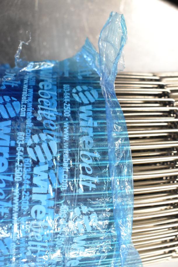 Brand new metal conveyor belt, scratch and dent condition. Wrapped in blue packaging marked "Wirebelt."