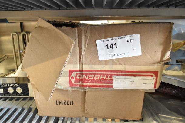 Cardboard box labeled "Northbend" containing a lot of new legs, screws, and washers. Box shows some damage. Auction tag reads "141."